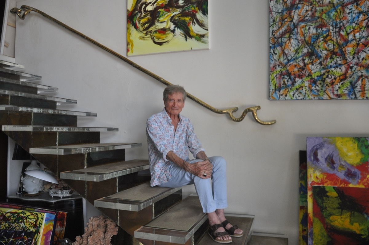 Robert Platania, assis parmi ses oeuvres